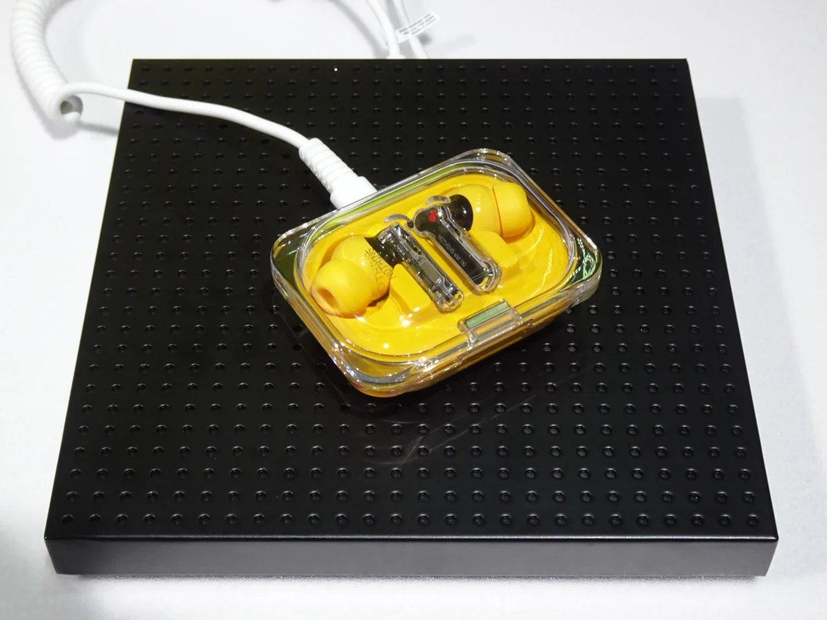 Yellow Nothing Ear (a) earbuds and case at a product display